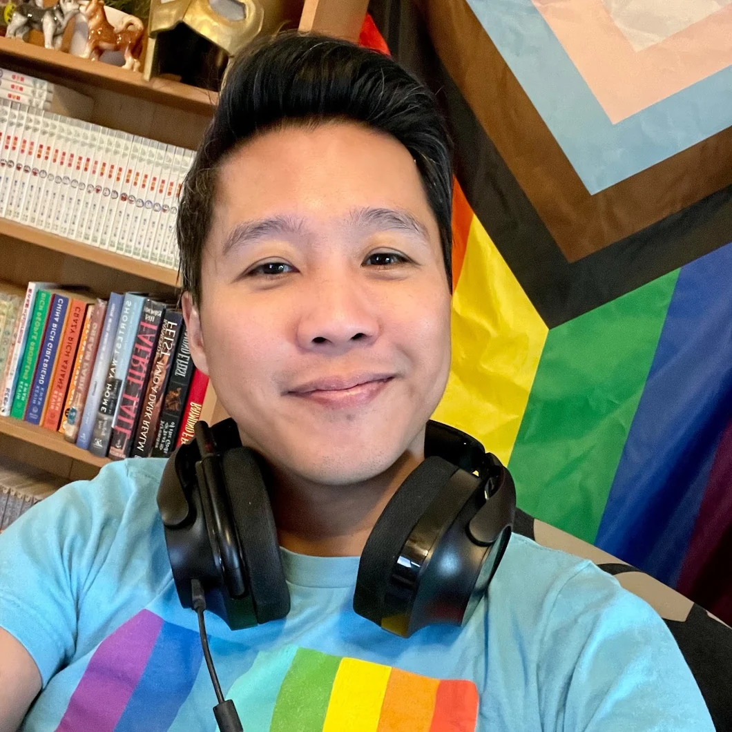 Ray with headphones, video games and books in the background